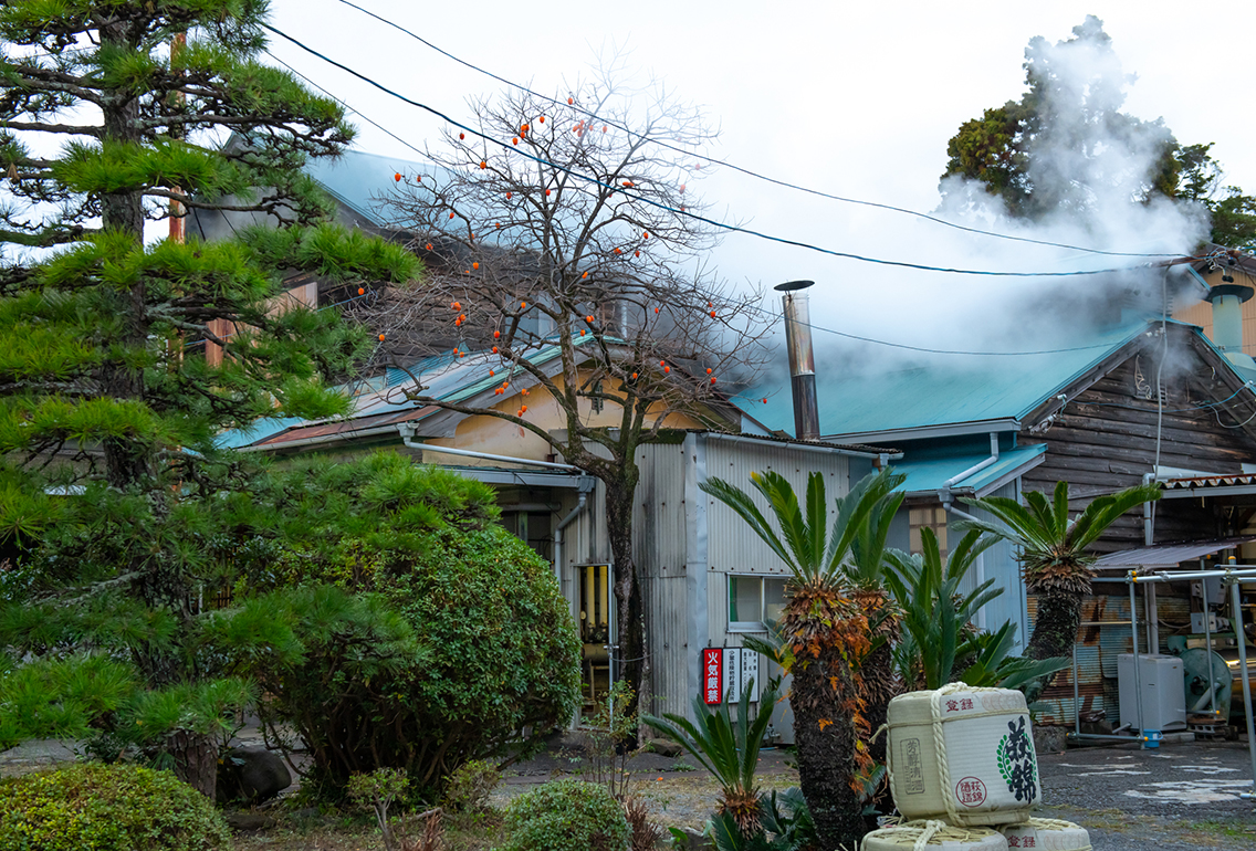 湯気が立つ萩錦酒造の建物と酒樽