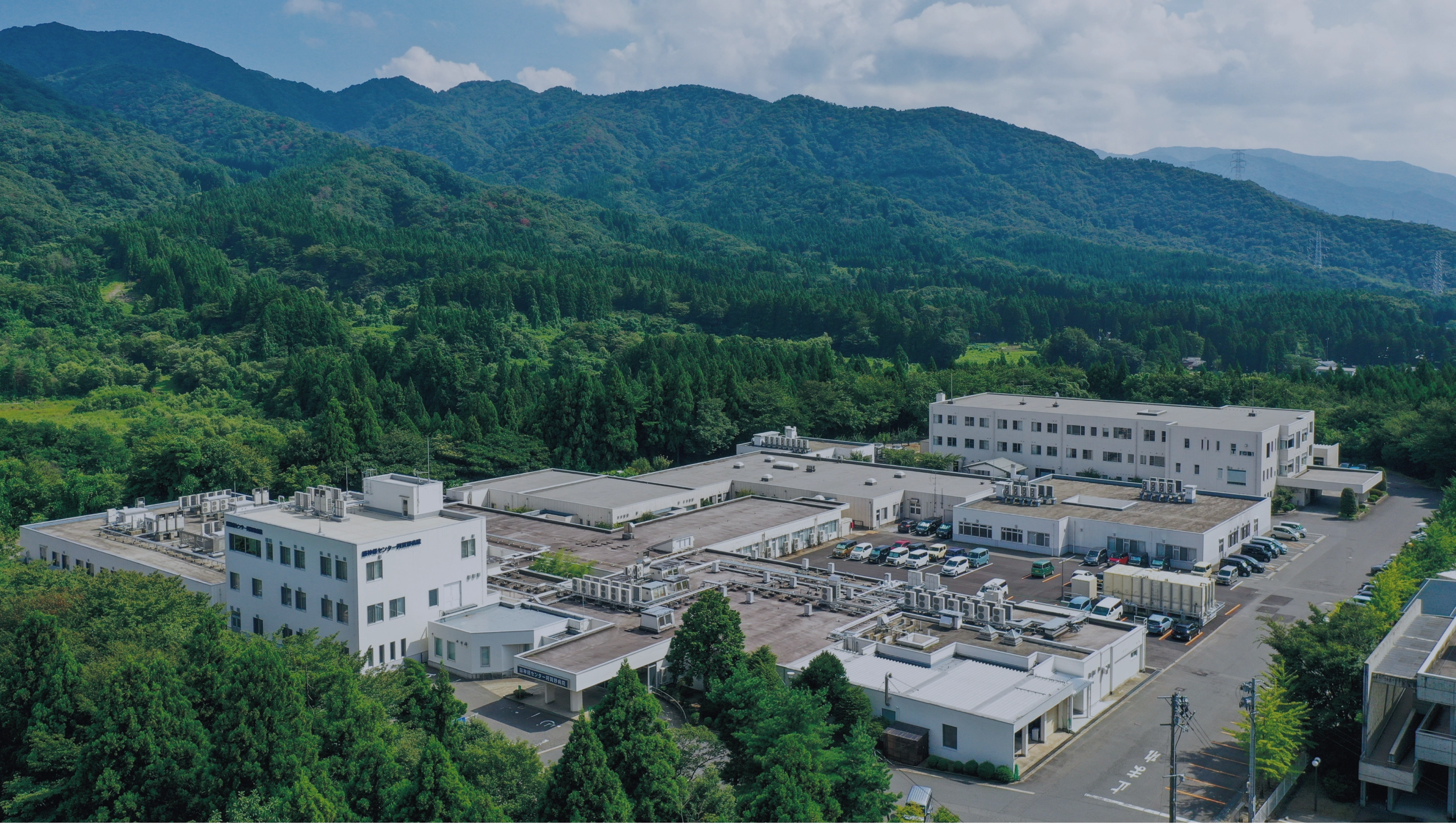 公式トップのスライドに掲載される五頭連峰の麓にある病院全景