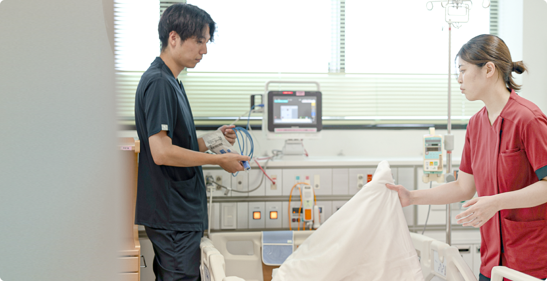 病床周辺で準備をする二人の医療スタッフ