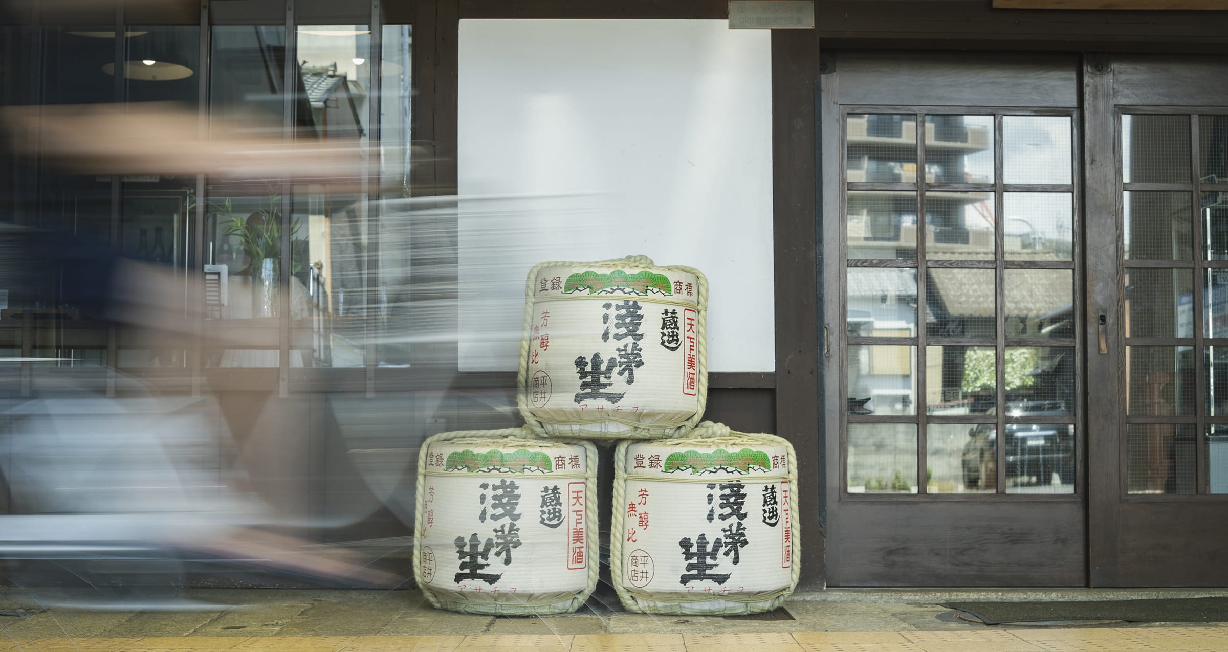 公式トップに掲載された、浅茅生の杉玉と木の引き戸がある酒蔵の入口