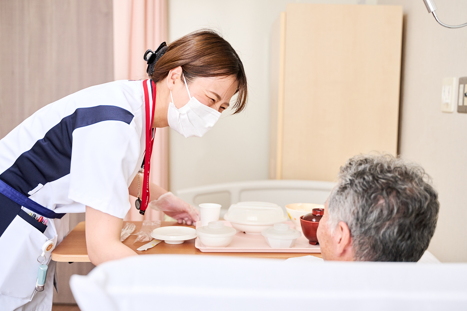 病室で患者に食事を届ける看護スタッフ