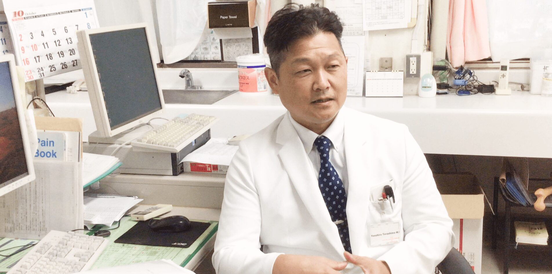 公式整形外科紹介に掲載された診察室で説明する医師