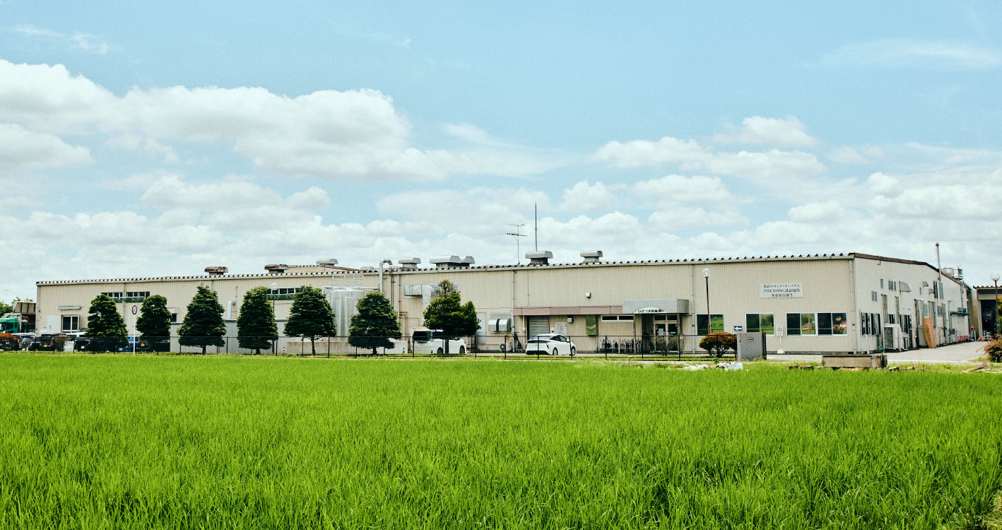 公式本社工場ギャラリーに掲載された、田園に面する本社工場外観