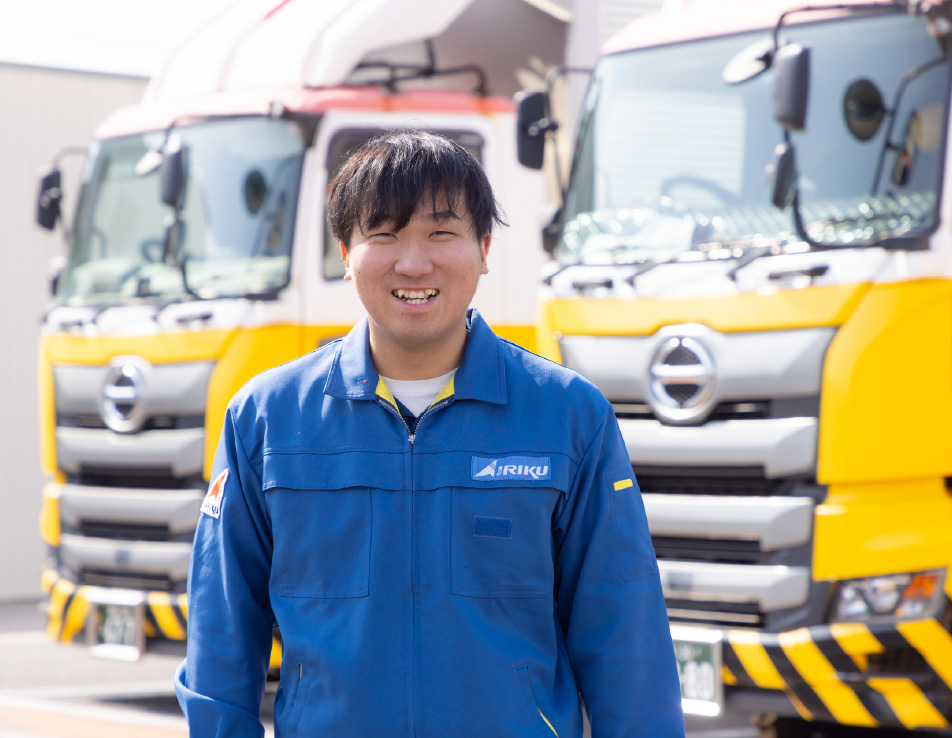 トラックの前で笑顔で立つT.Oさん