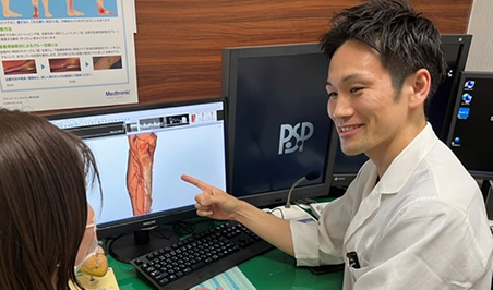 医師が画像を示して相談者に説明する場面