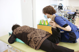 療法士がベッド上で利用者を支援する様子