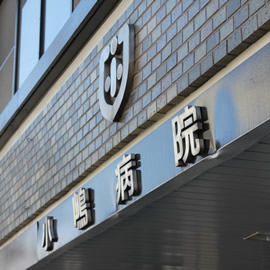 小嶋病院の名称とエンブレムを写した外観