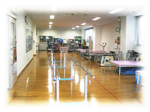 平行棒、訓練台、車椅子を備えたリハビリテーション室