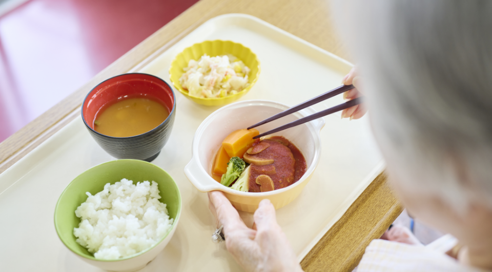 利用者が箸で食事を取る様子