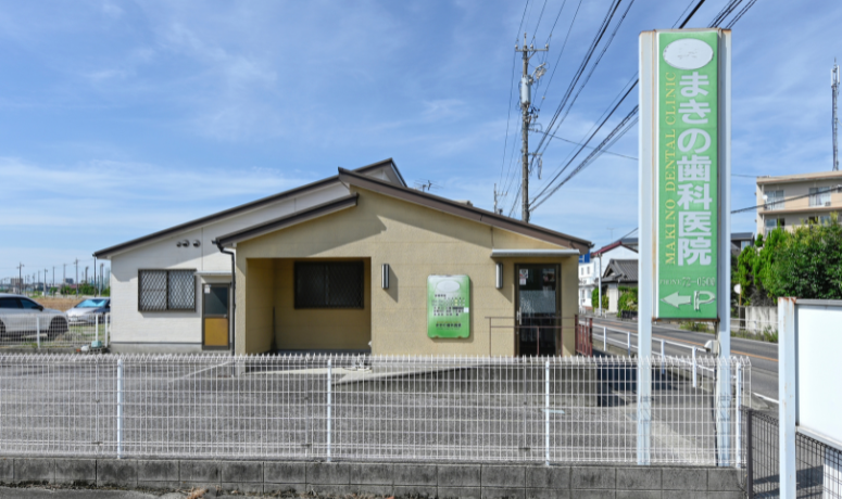 医院名と入口案内の看板が見えるまきの歯科医院の外観
