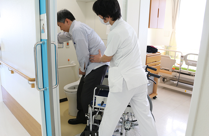スタッフが利用者のトイレ動作を支援する様子