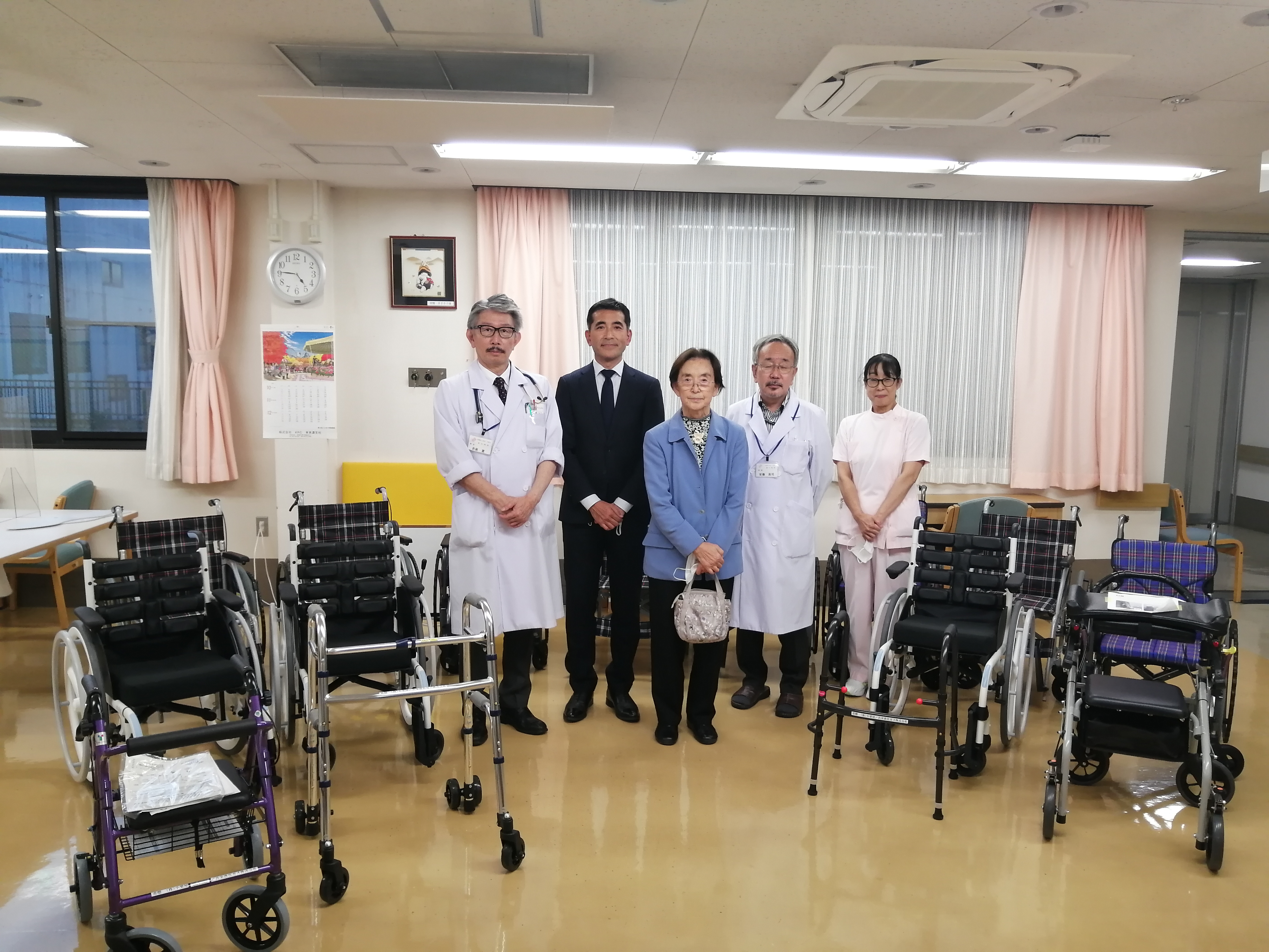 公式トピックス掲載の城山病院内のスタッフと車椅子