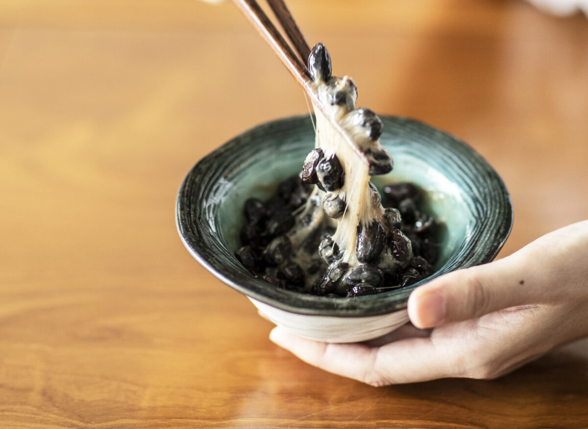 器に盛った黒豆納豆を箸で持ち上げる写真
