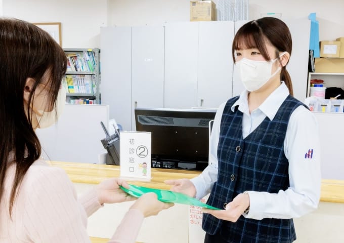 練馬総合病院の外来受付で案内するスタッフ