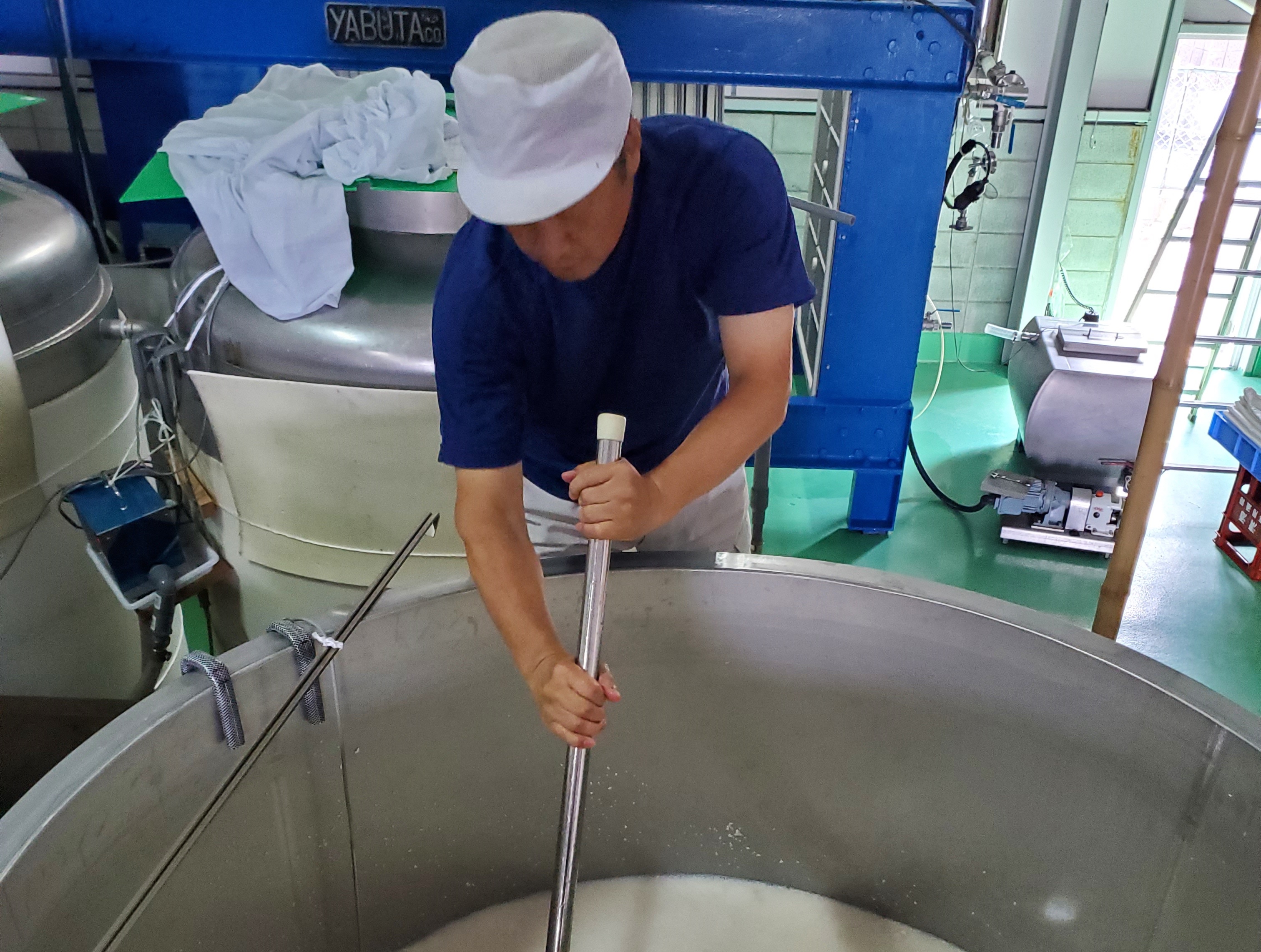 仕込みタンクでもろみをかき混ぜる作業