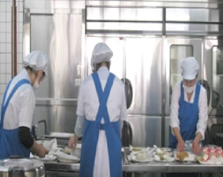 給食を盛り付ける栄養課の職員