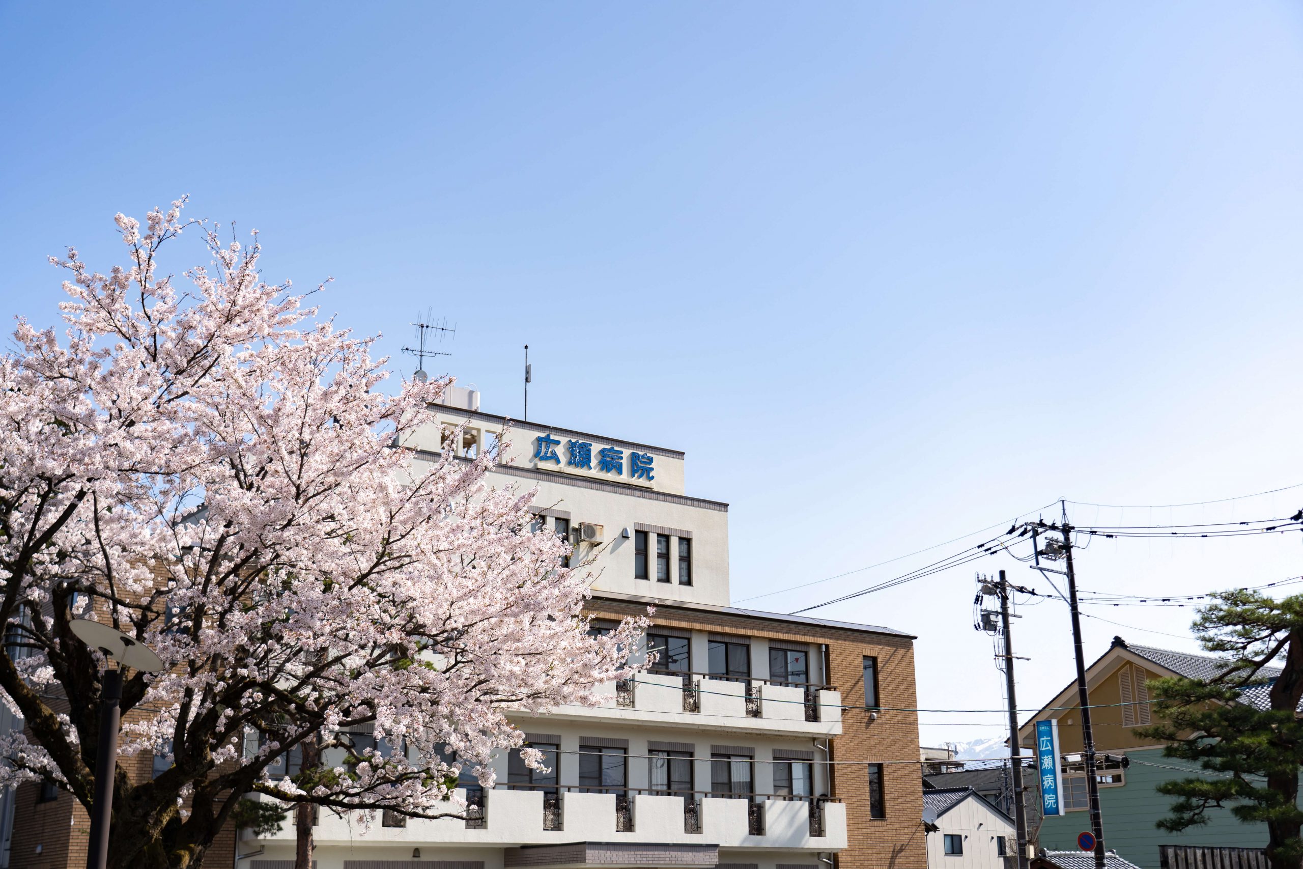 公式トップに掲載された、建物名表示と桜が見える広瀬病院の外観