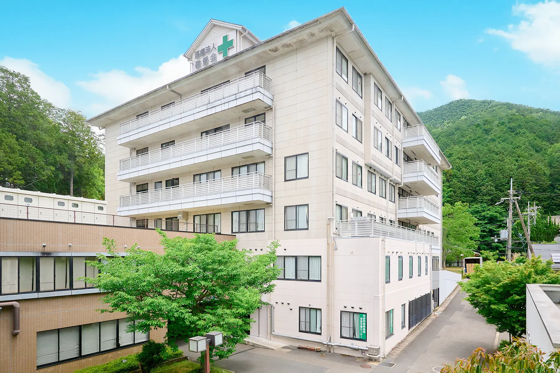 療養病棟と自然に囲まれた病院敷地を示す公式写真