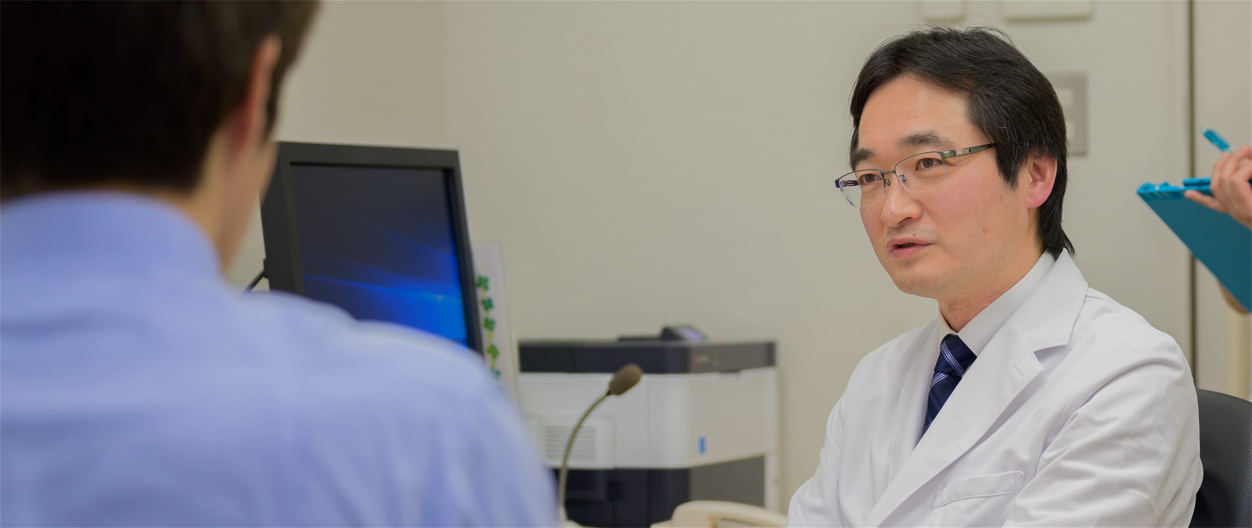 公式トップに掲載された医師と患者の診察場面