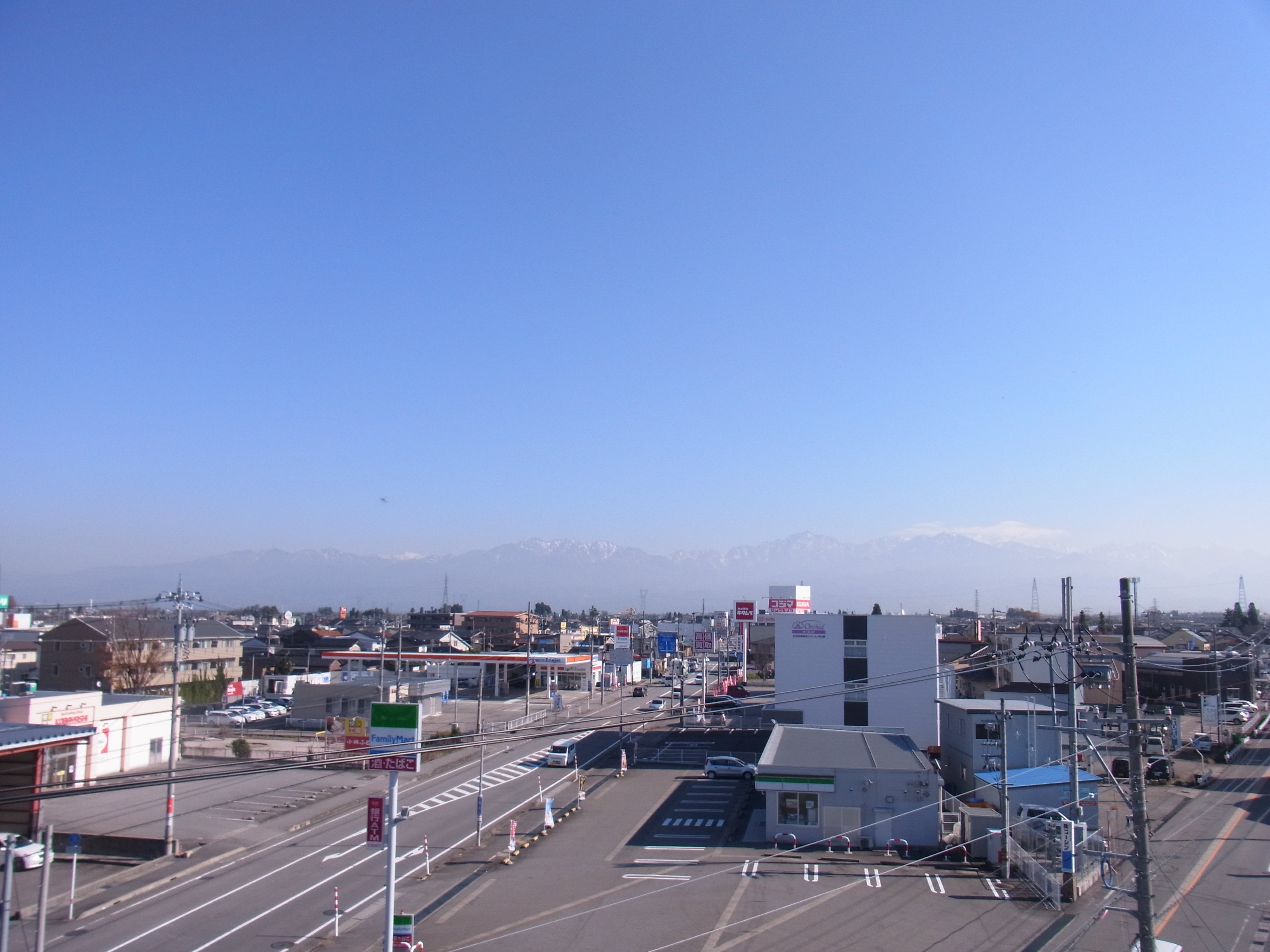 公式サイトの画像資産に掲載された富山市街と立山連峰の風景