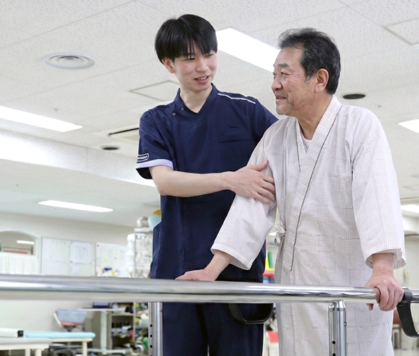 療法士が患者を支えるリハビリテーションの様子