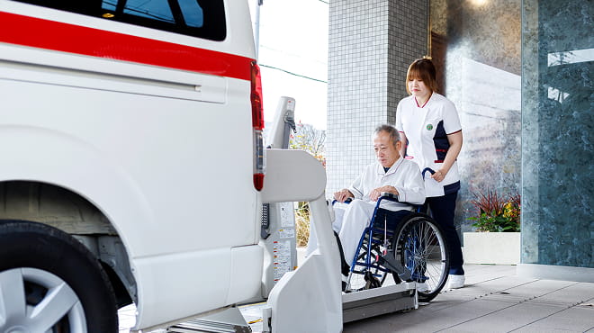 救急車と車椅子の患者を支える看護師