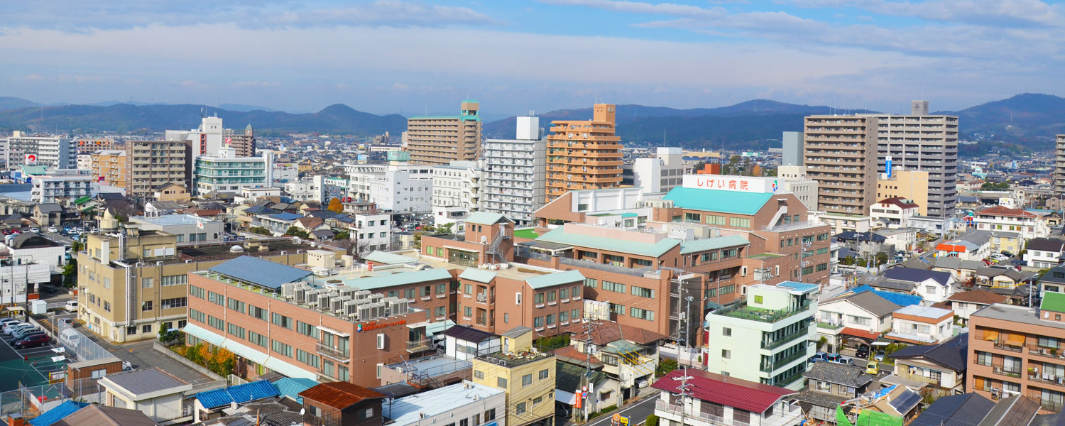 公式トップの航空写真に写るしげい病院の建物と倉敷の周辺景観