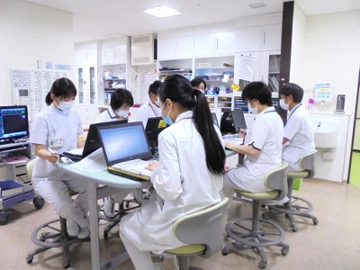 看護スタッフが病室内で情報共有する様子