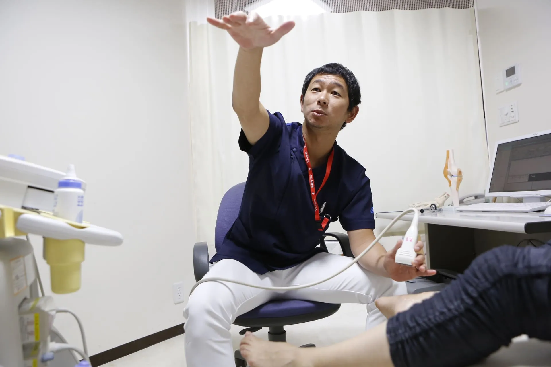 下肢・足病総合センターで医師が足の診察について説明する様子