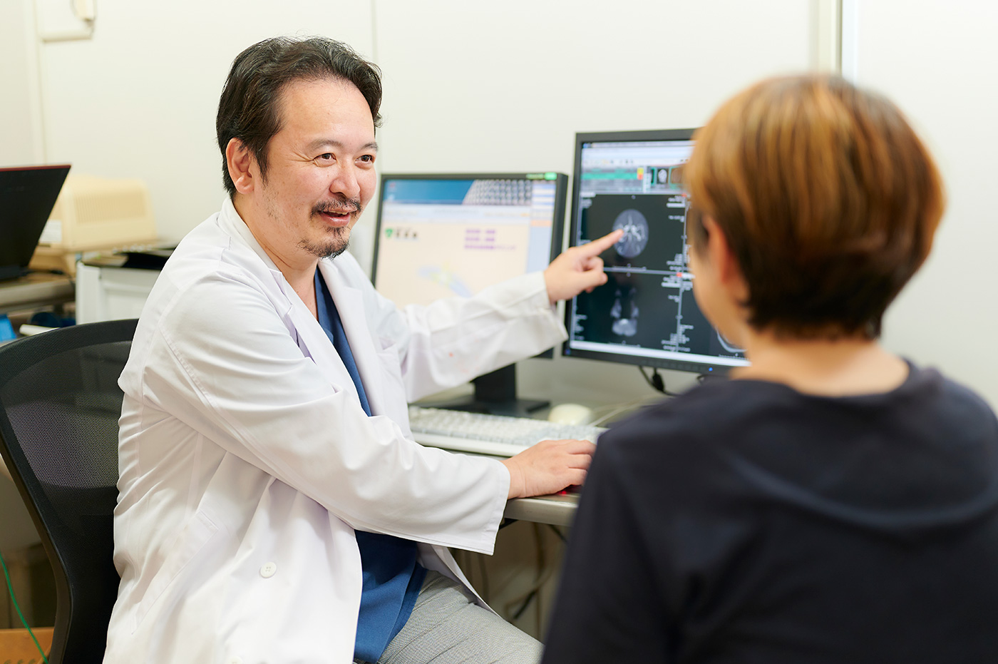 画像を見ながら患者に説明する医師