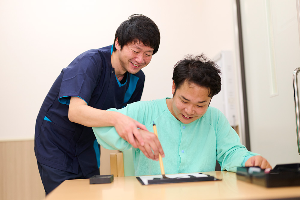 作業療法士と患者の机上訓練