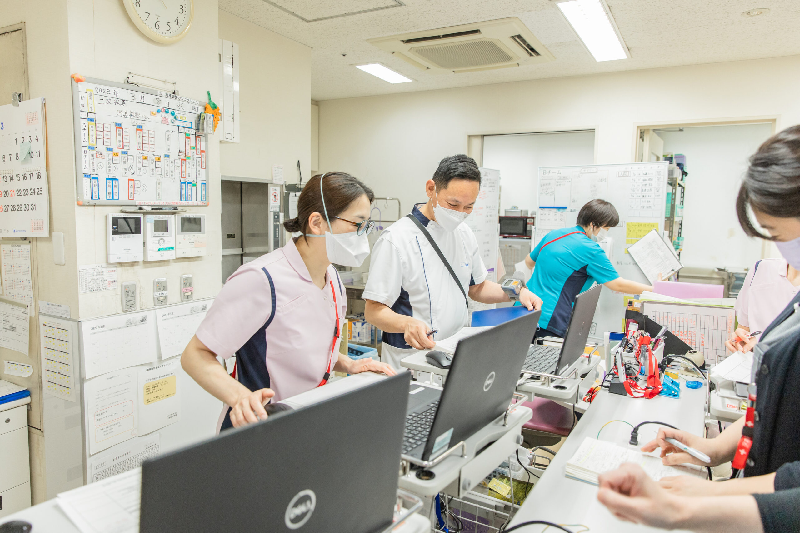 病棟の廊下を歩く患者と職員
