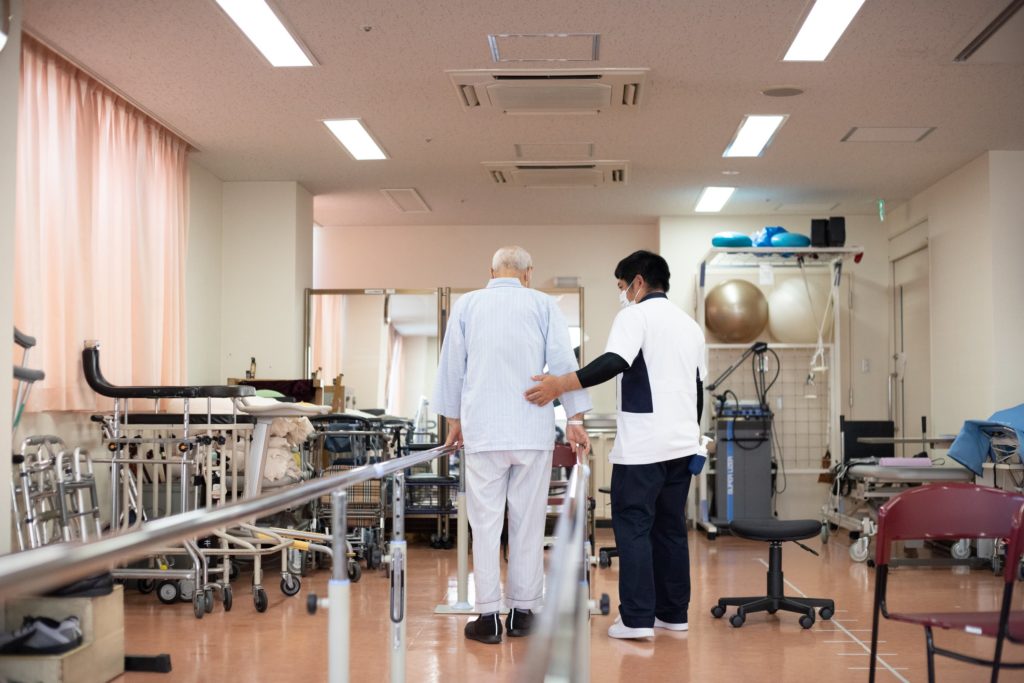 歩行訓練を支える療法士と患者