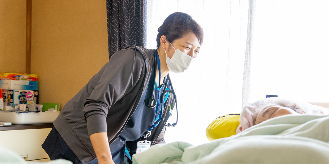 病棟で患者に寄り添う看護師