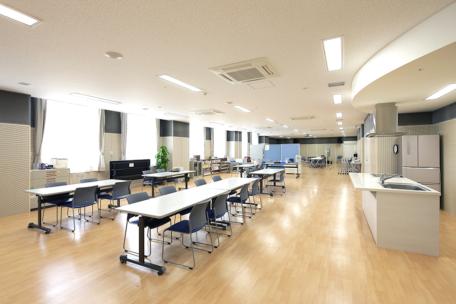 机、椅子、簡易キッチンを備えた作業療法室