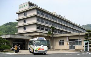 公式概要沿革に掲載される旧病院建物と送迎バス