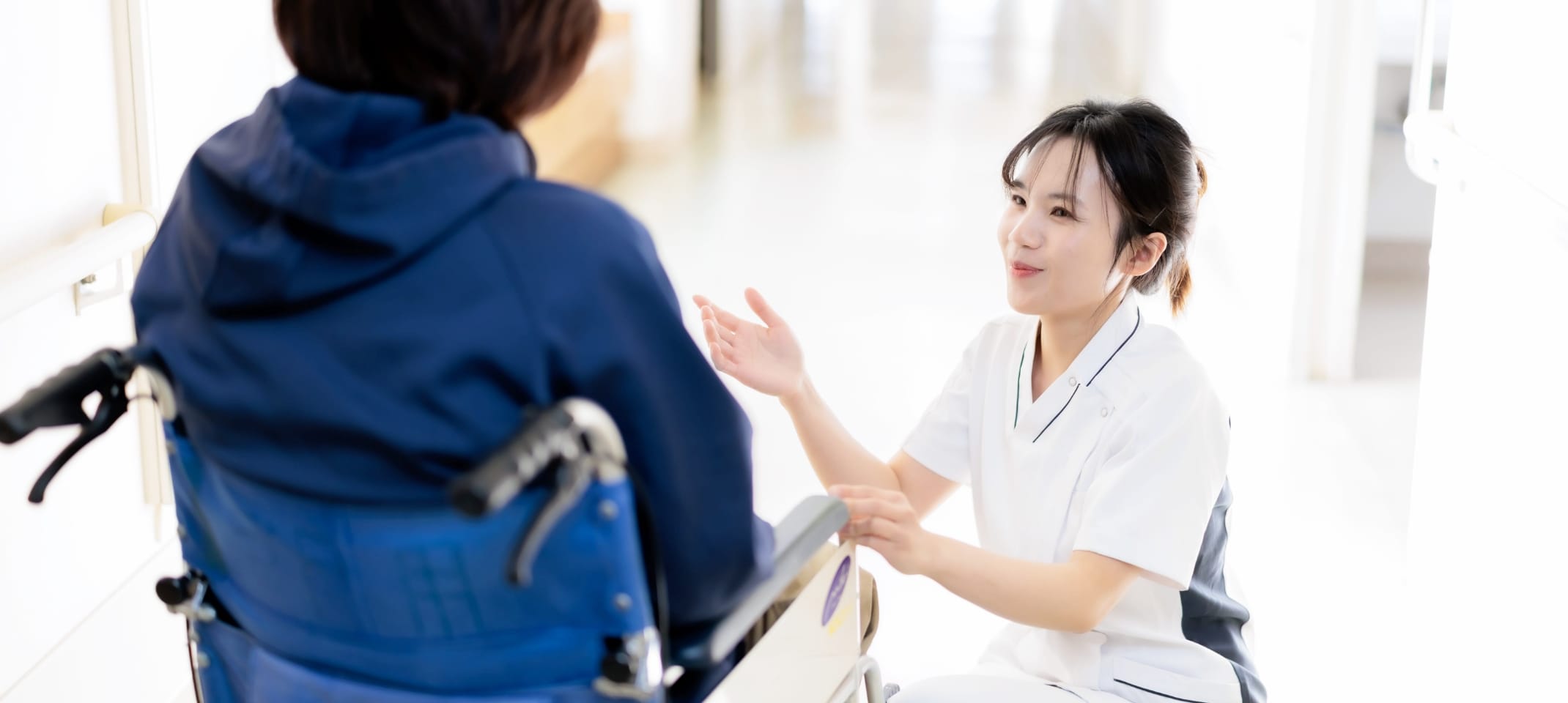 公式の特長ページに掲載される、看護師が車いすの患者を支える様子