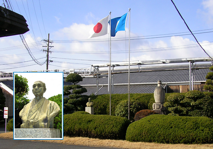 公式歴史ページに掲載された、旗と木造蔵が見える江井ヶ嶋酒造の敷地外観