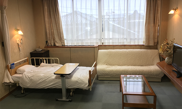 公式施設案内に掲載された、ベッドとソファを備える特室の病室