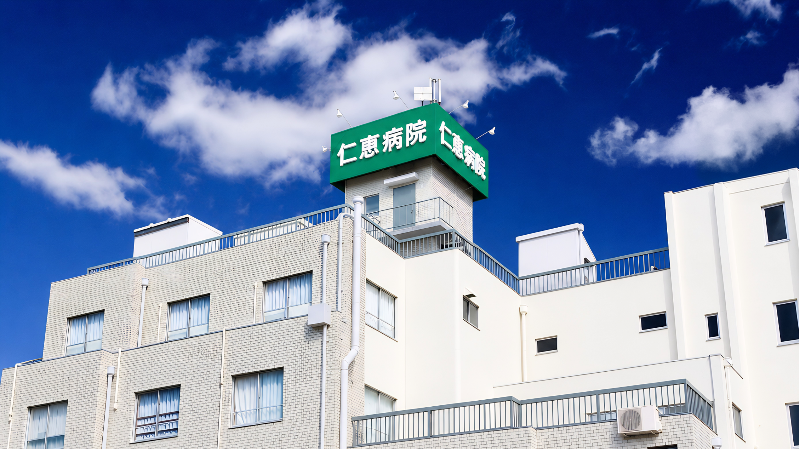公式トップのCSS背景に使われる、病院名の看板が見える建物外観
