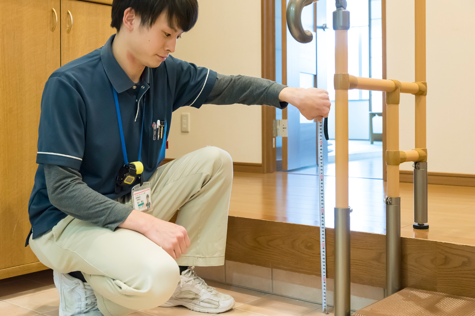在宅復帰に向けた手すりと段差の確認を行うリハビリスタッフ