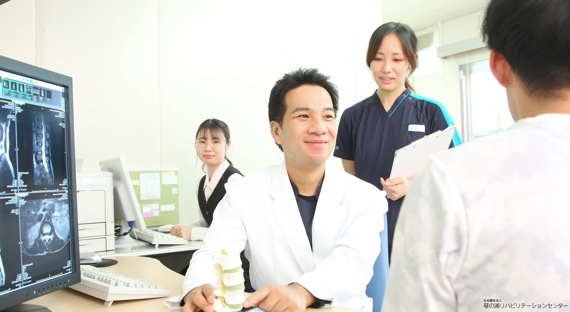 診察室で医師とスタッフが患者に説明する様子