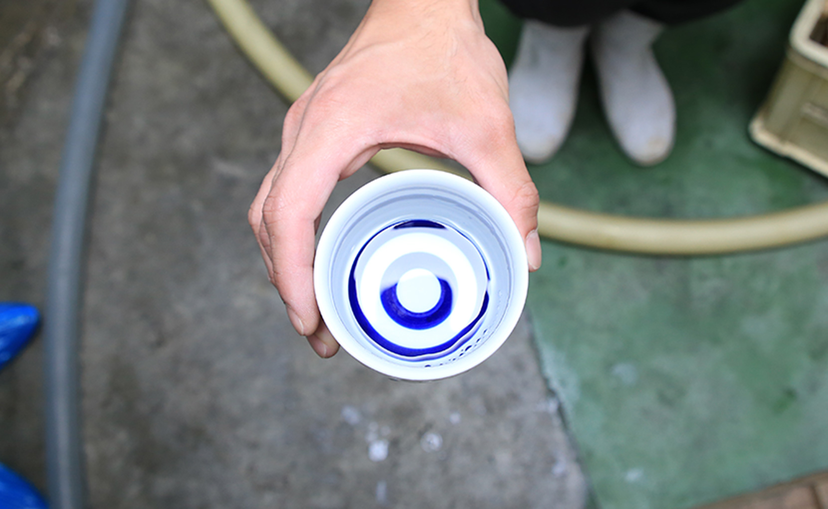 公式の酒造りページに掲載された、酒を杯に受けて確認する手元
