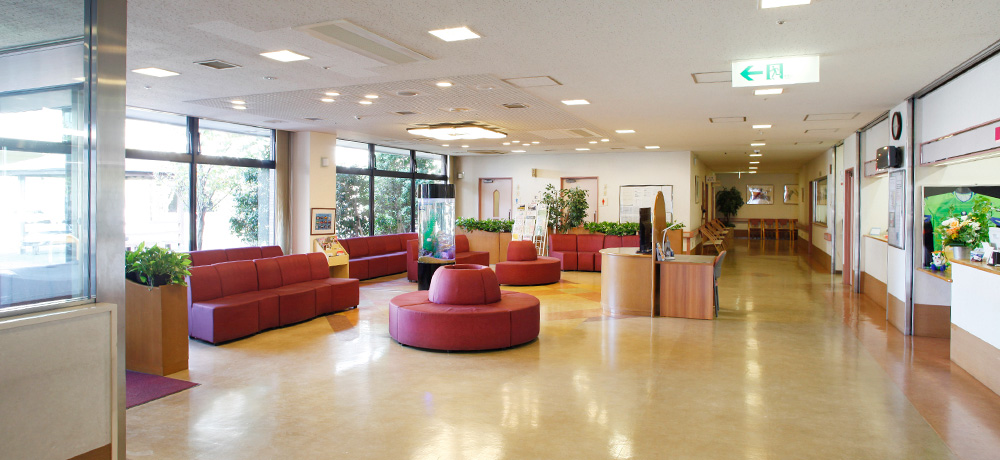 公式トップのスライドに掲載された、赤いソファと受付を備えた無人の院内空間