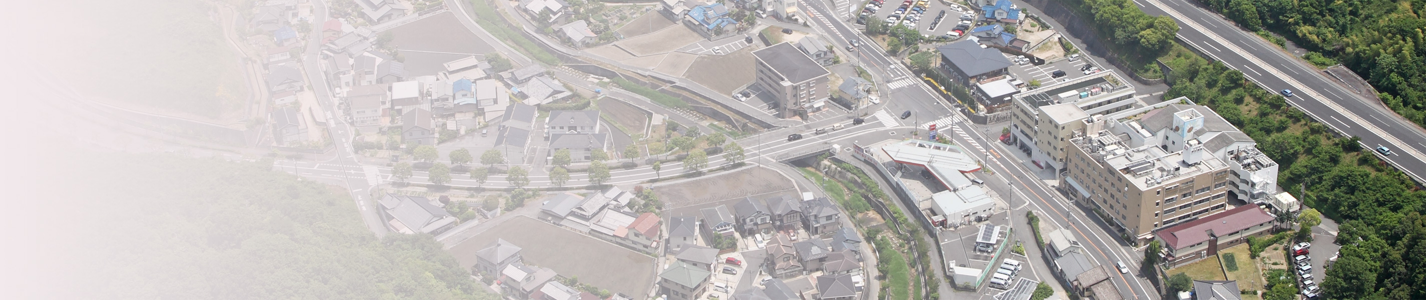 上空から見た廿日市野村病院の建物と周辺地域