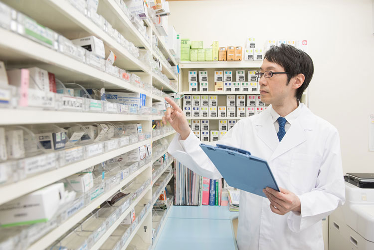 薬品棚を確認する薬剤師