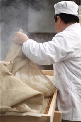 蒸気の立つ仕込み作業を行う蔵人