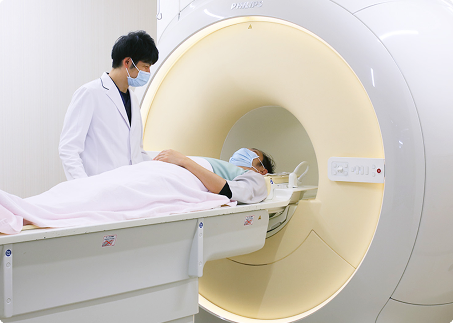 公式トップの診療案内に掲載された、MRI検査を行う医師と患者