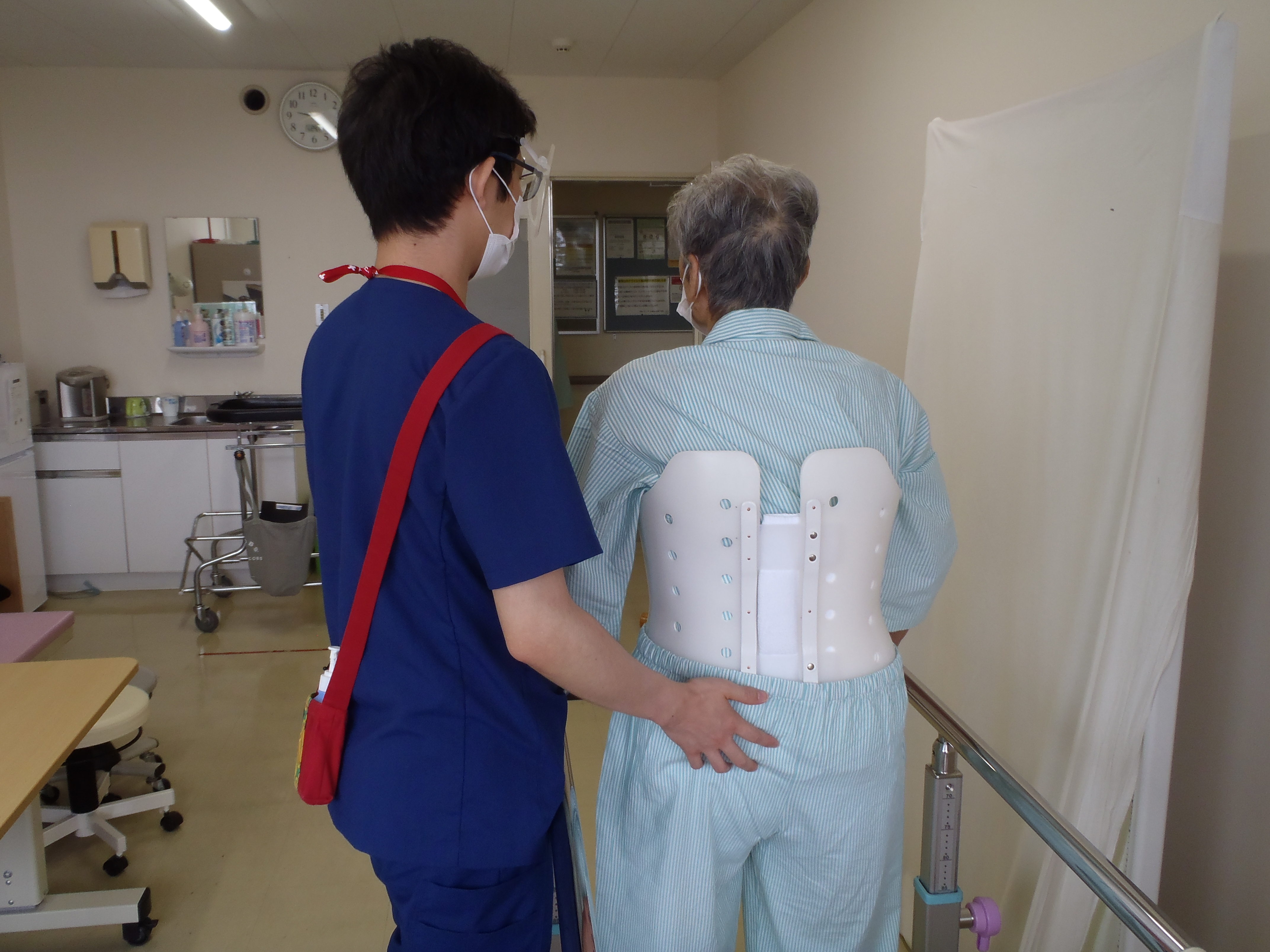 歩行訓練を支援する理学療法士と患者