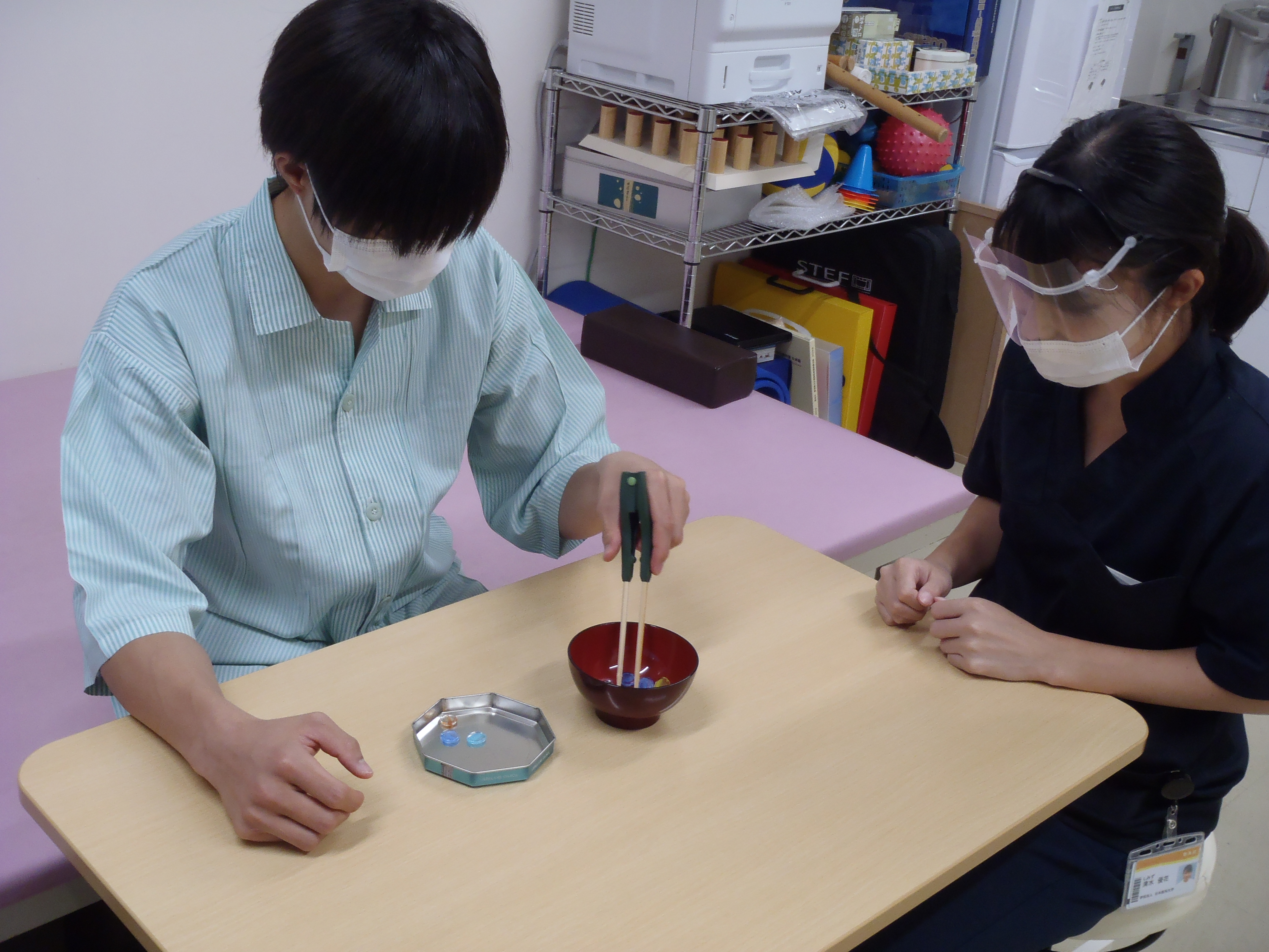食事動作の練習を支援する作業療法士と患者